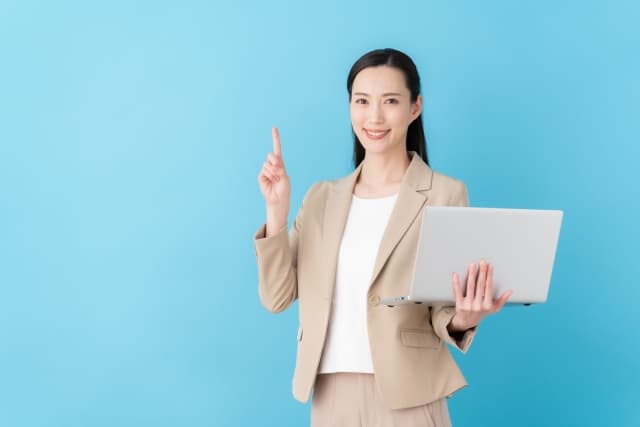 ノートパソコンを持って説明をする女性